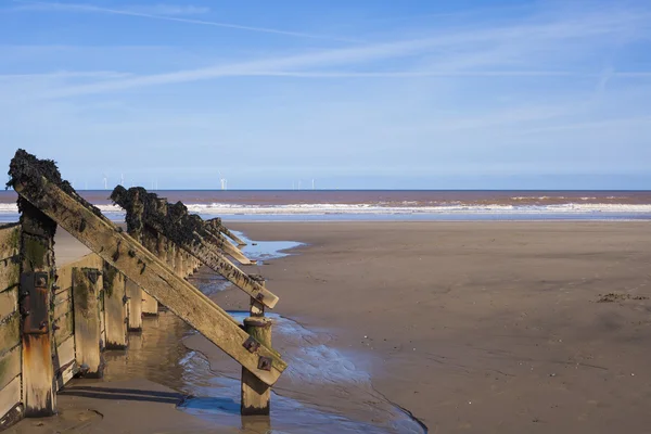 Wooden wave breakers at seaside — Stock Photo, Image