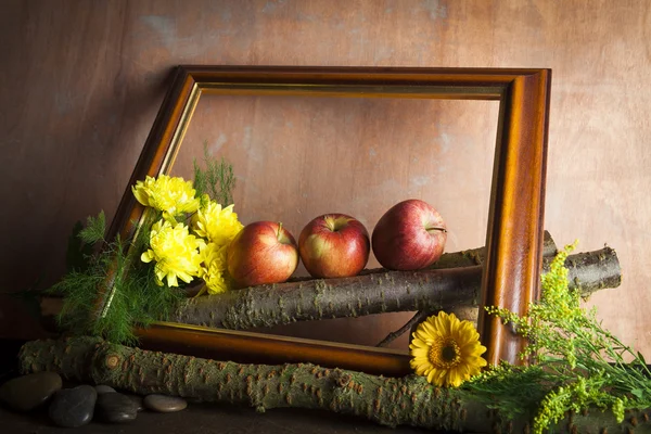 Manzanas rojas y flores en marco de madera Fotos De Stock