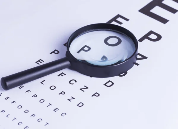 Magnifying glass and eye test — Stock Photo, Image