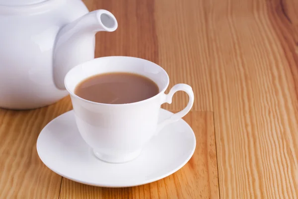 Cup of traditional English Tea with white china teapot — Stock Photo, Image