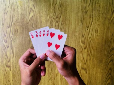 Hands playing cards for fun hobby and engaging leisure time activity.