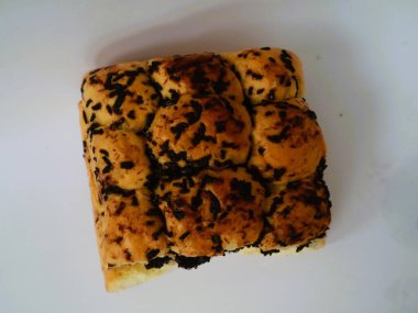 Temiz beyaz bir zemin üzerinde izole edilmiş, nefis çikolata dolu bir ekmek, menü tasarımı, fırın reklamları ve dijital gıda içeriği için ideal.