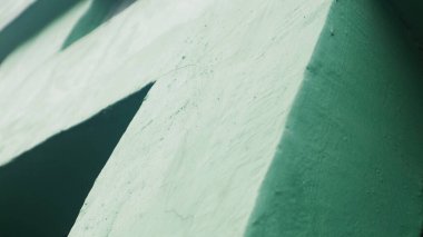 Yarı parlak, yeşil desenli arka plan, siyah dikdörtgen kesimli, materyalin yüzey detaylarını gösteren..