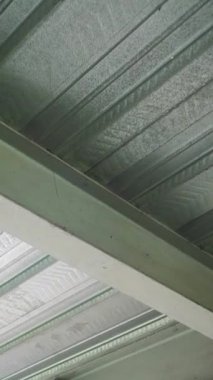 Metal bir tavana yakın çekim, desenli bir tasarım, kıvrımlı paneller ve yükseltilmiş dikişler, desenli, endüstriyel tarzda estetik