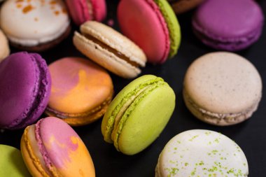 Karanlık bir arka plan üzerinde çeşitli renkli macaroons