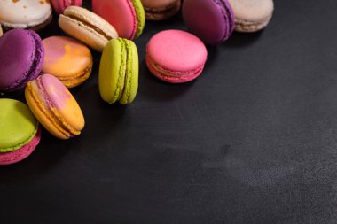 Karanlık bir arka plan üzerinde çeşitli renkli macaroons