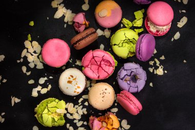 Karanlık bir arka plan üzerinde çeşitli renkli macaroons