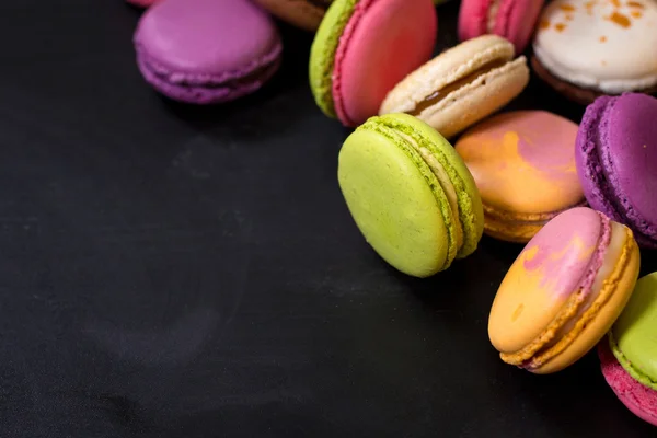 Verschiedene bunte Makronen auf dunklem Hintergrund — Stockfoto