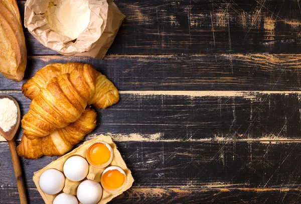 Croissants, baguette, harina, huevos, fondo de cuchara — Foto de Stock