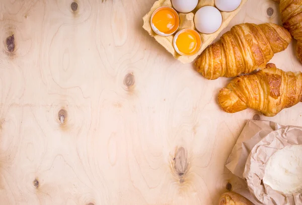 Croissants, baguette, flour, eggs background — Stock Photo, Image