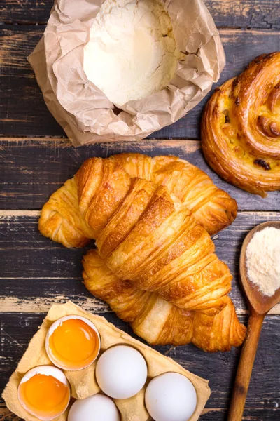 Croissants, raisin snail, flour, eggs, spoon — Stock Photo, Image