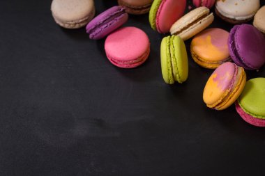 Karanlık bir arka plan üzerinde çeşitli renkli macaroons