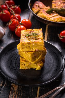 Siyah bir tabak üzerinde tortilla de patatas dilim