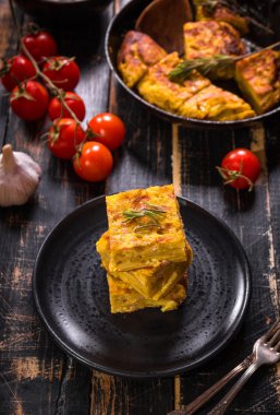 Siyah bir tabak üzerinde tortilla de patatas dilim