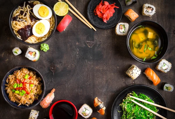 Sushi e comida japonesa no fundo escuro — Fotografia de Stock