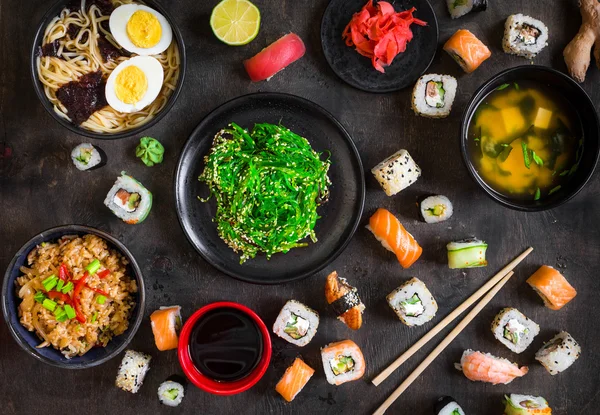 Mesa servida com sushi e comida tradicional japonesa — Fotografia de Stock