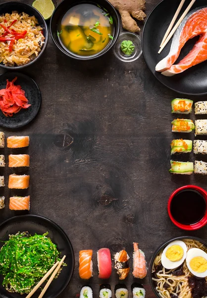 Sushi e comida japonesa no fundo escuro — Fotografia de Stock