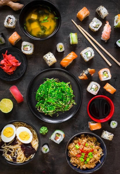 Mesa servida com sushi e comida tradicional japonesa — Fotografia de Stock