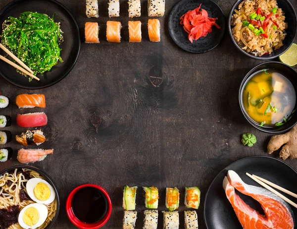 Sushi y comida japonesa sobre fondo oscuro — Foto de Stock