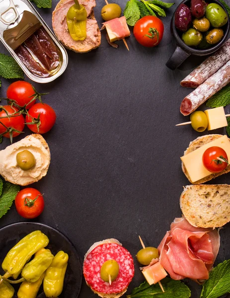 Tapas españolas sobre fondo de piedra negra — Foto de Stock