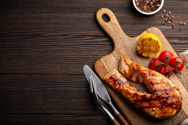 Koyu ahşap arka planda ızgara somon bifteği.