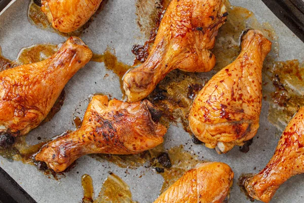 Roasted or grilled chicken legs drumsticks on baking tray — Stock Photo, Image