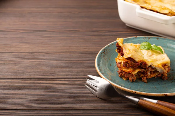 Traditionell italiensk lasagne på tallrik på träbord kopieringsutrymme — Stockfoto