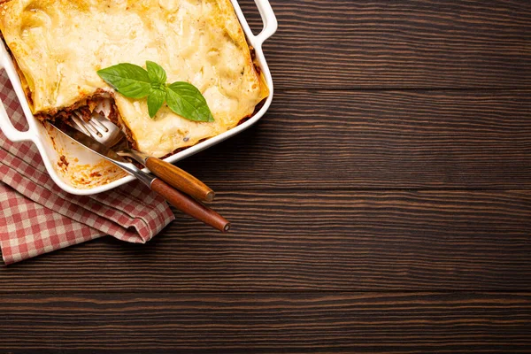 Traditional Italian lasagna in casserole pan on wooden table — Stock Photo, Image