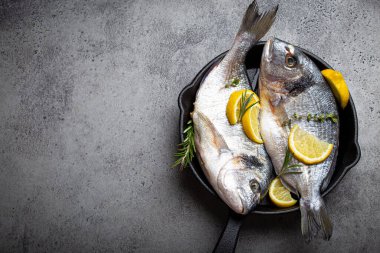 Çiğ balık çipurası ya da dökme demir tavada dorado.