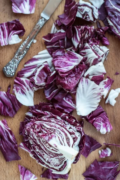 Skivad radicchio på träbord. Selektiv inriktning. Vertikal — Stockfoto