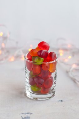 Jellies in a glass on table with garland lights. Selective focus clipart