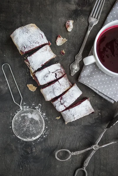 Cherry and walnut strudel on a dark wooden  table. Selective foc — Stock Photo, Image