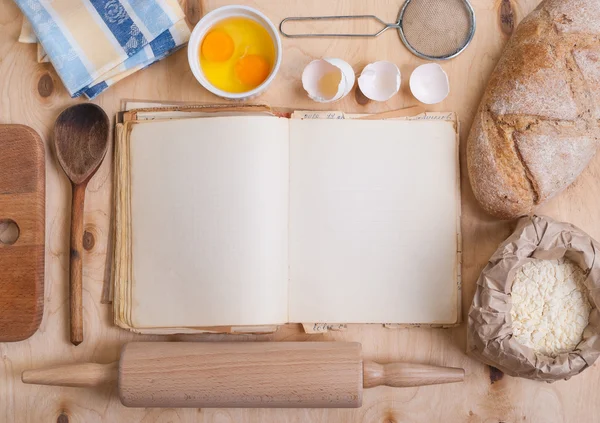 Fond de cuisson avec livre de cuisine vierge, coquille d'oeuf, farine, rouleau — Photo