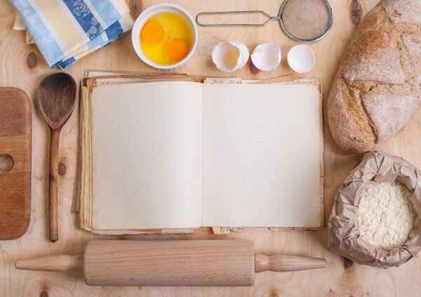 Baking background with blank cook book, eggshell, flour, rolling