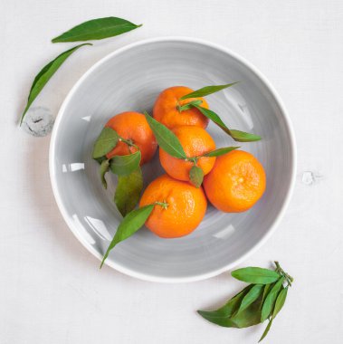 Mandalina Beyaz ahşap zemin üzerine yeşil yaprakları ile