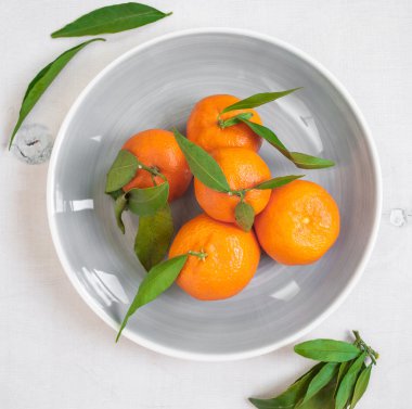 Mandalina Beyaz ahşap zemin üzerine yeşil yaprakları ile. Yakın u