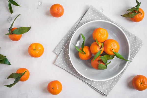 Tangeriner på vit trä bakgrund. Grå polka dot tyg — Stockfoto