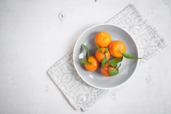 Tangeriner på vit trä bakgrund. Grå servett — Stockfoto