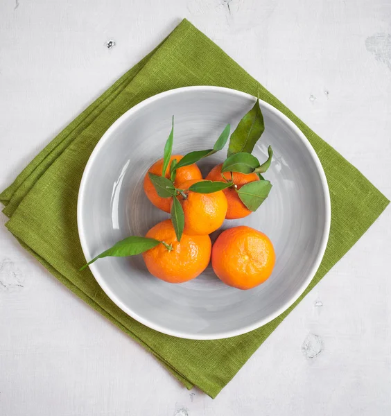 Tangeriner på vit trä bakgrund och grönt tyg — Stockfoto