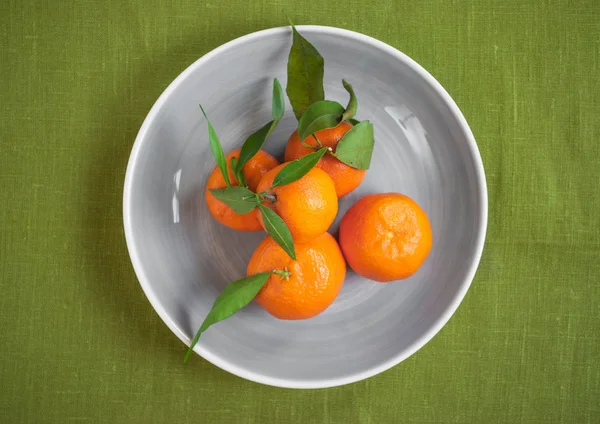 Tangerines on green fabric background — Stock Photo, Image