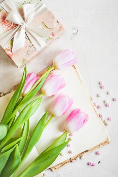 Tulipani rosa con confezione regalo su tavolo di legno bianco — Foto Stock