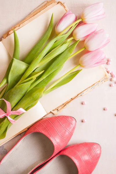 Tulipanes rosados con zapatos de mujer sobre mesa de madera blanca. Primavera c — Foto de Stock