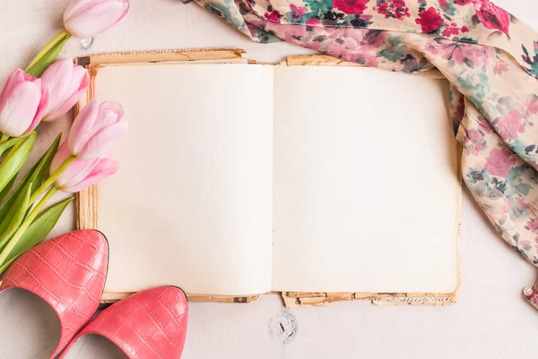 Розовые тюльпаны и чистая книга с женской обувью поверх белого дерева — стоковое фото