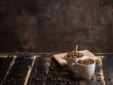 Fincan kahve çekirdekleri, koyu ahşap arka plan ile