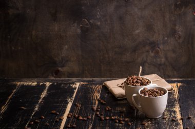 Fincan kahve çekirdekleri, koyu ahşap arka plan ile
