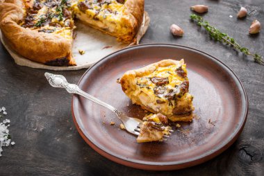 Koyu ahşap backgrou üzerinde keçi peyniri ile sarımsak tart karamelize