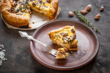 Koyu ahşap backgrou üzerinde keçi peyniri ile sarımsak tart karamelize