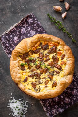 Koyu ahşap backgrou üzerinde keçi peyniri ile sarımsak tart karamelize