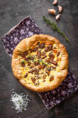 Koyu ahşap backgrou üzerinde keçi peyniri ile sarımsak tart karamelize