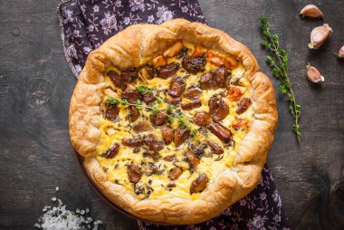 Koyu ahşap backgrou üzerinde keçi peyniri ile sarımsak tart karamelize